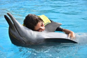 mujer abrazando a un delfin