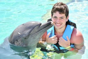 chico nadando con delfines en cancun