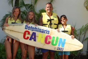 familia nadando con delfines