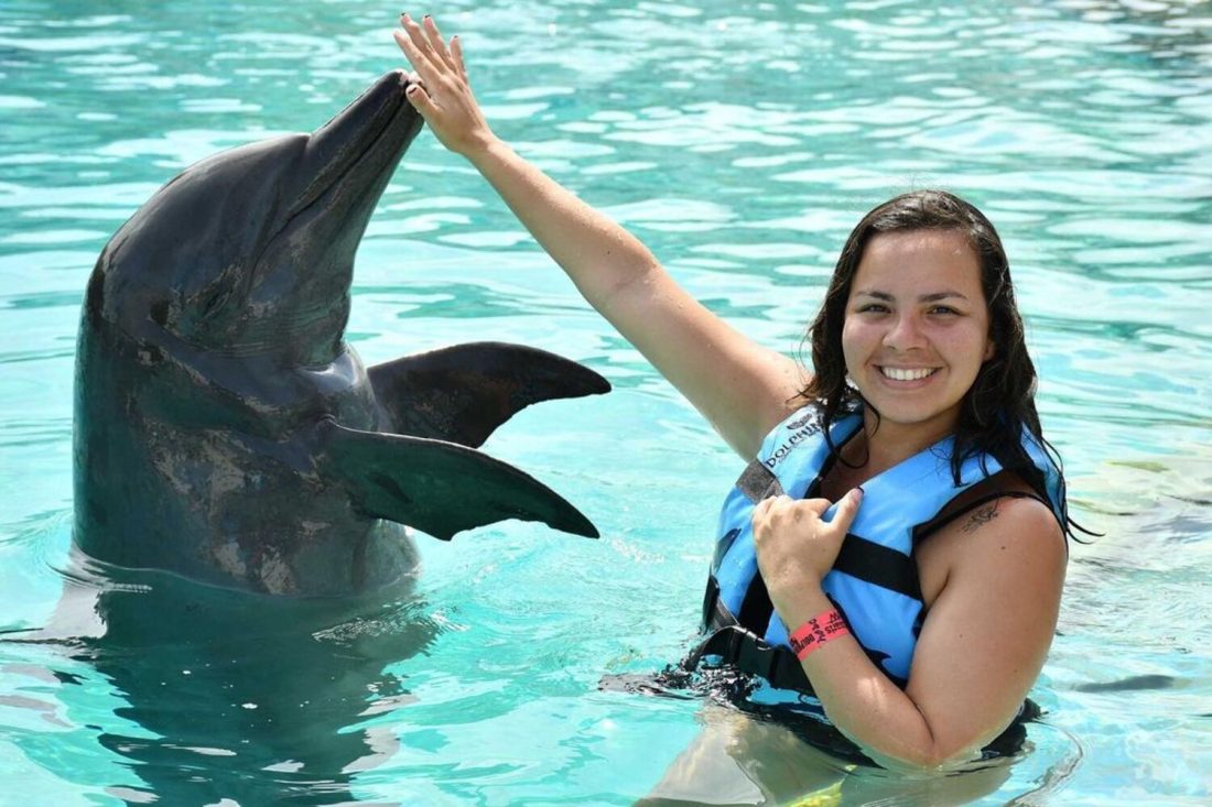 mujer nadando con un delfin